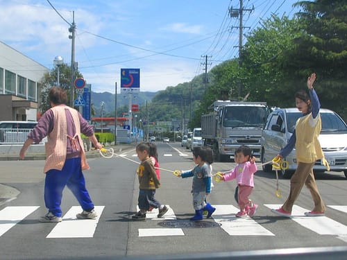 An der Leine: Kinder überqueren die Strasse.