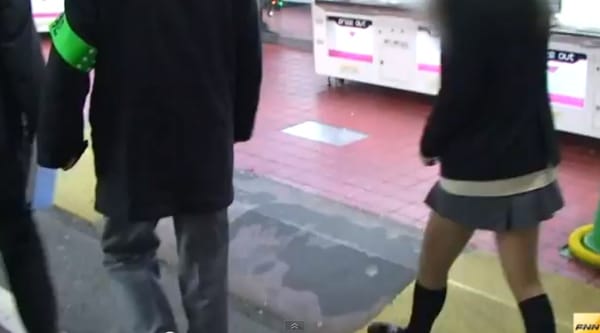 Ein Schülerin wird von einem Polizisten in Akihabara befragt.