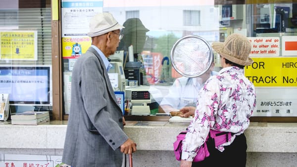 Ein älteres Ehepaar im Bahnhof Miyajima bei Hiroshima.